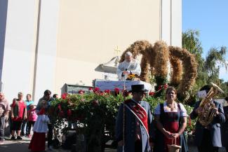 Stabführer Robert Nagl und Marketenderin Maria Schuller vor dem Pfarrer und der Erntekrone