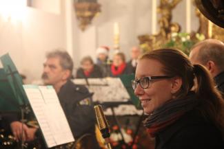 Saxophonisting Katja Ondracek und weitere Mitglieder des Musikvereins im Hintergrund.