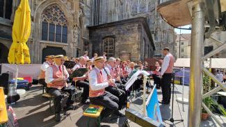 Der Musikverein Leopoldau auf der Bühne und im Hintergrund der Stephansdom.