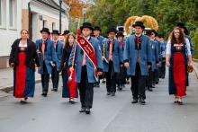 Der Musikverein Leopoldau beim Umzug am Leopoldauer Platz mit der Erntekrone im Hintergrund.