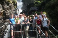 Eine Wandergruppe vor einem Wasserfall.